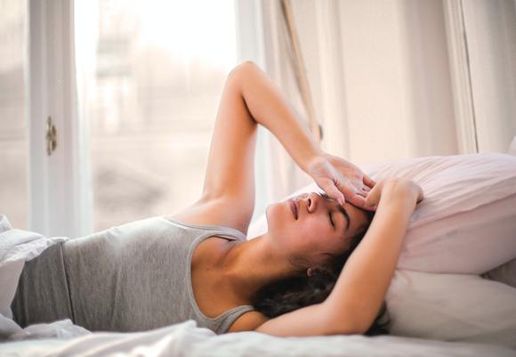 Woman in gray tank top lying on bed 3768582